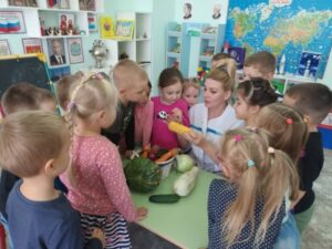 Воспитанники старшей комбинированной группы рассматривают овощи с воспитателем Котовой Н.В.