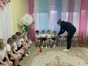 Елена Владимировна учит детей передавать мяч и правильно держать его в руках