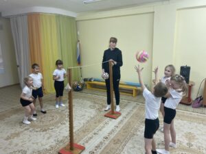Елена Владимировна с ребятами отрабатывают приёмы работы с мячом. Переброс мяча через импровизированную сетку.