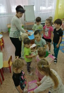 Воспитанники старшей группы  дарят книги  малышам из первой младшей группы